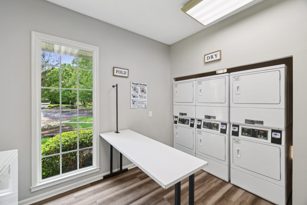 Photo of laundry room with table and dryers
