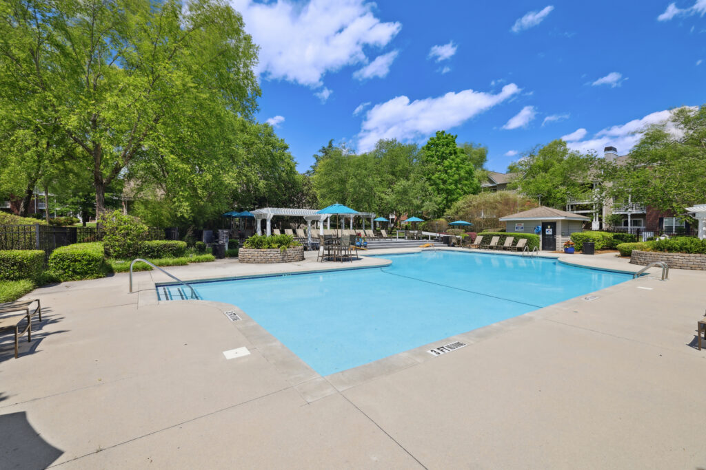 Photo of pool with chairs and umbrellas on the sides